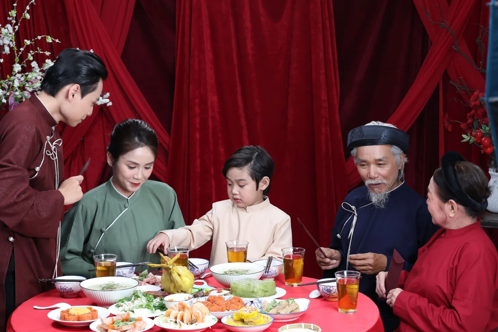 Gia đình ba thế hệ mặc áo dài quây quần bên mâm cơm ngày Tết