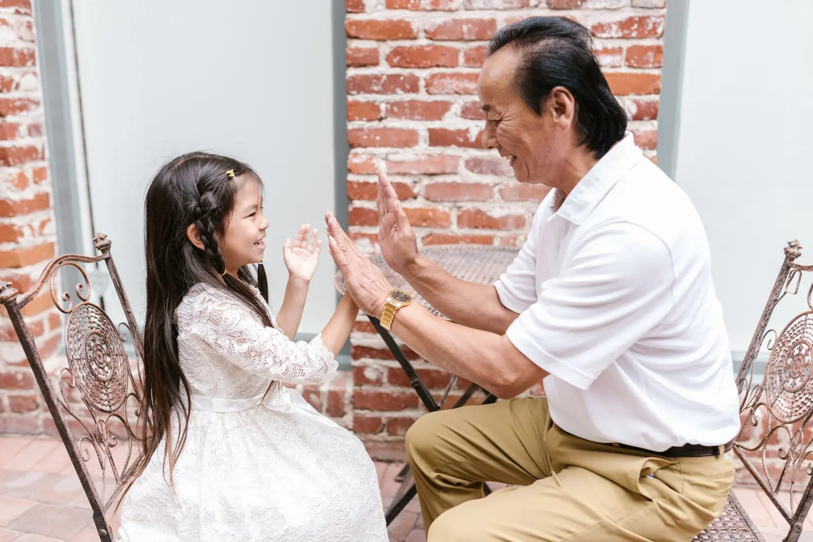 Ông và cháu gái chơi vỗ tay trong nhà