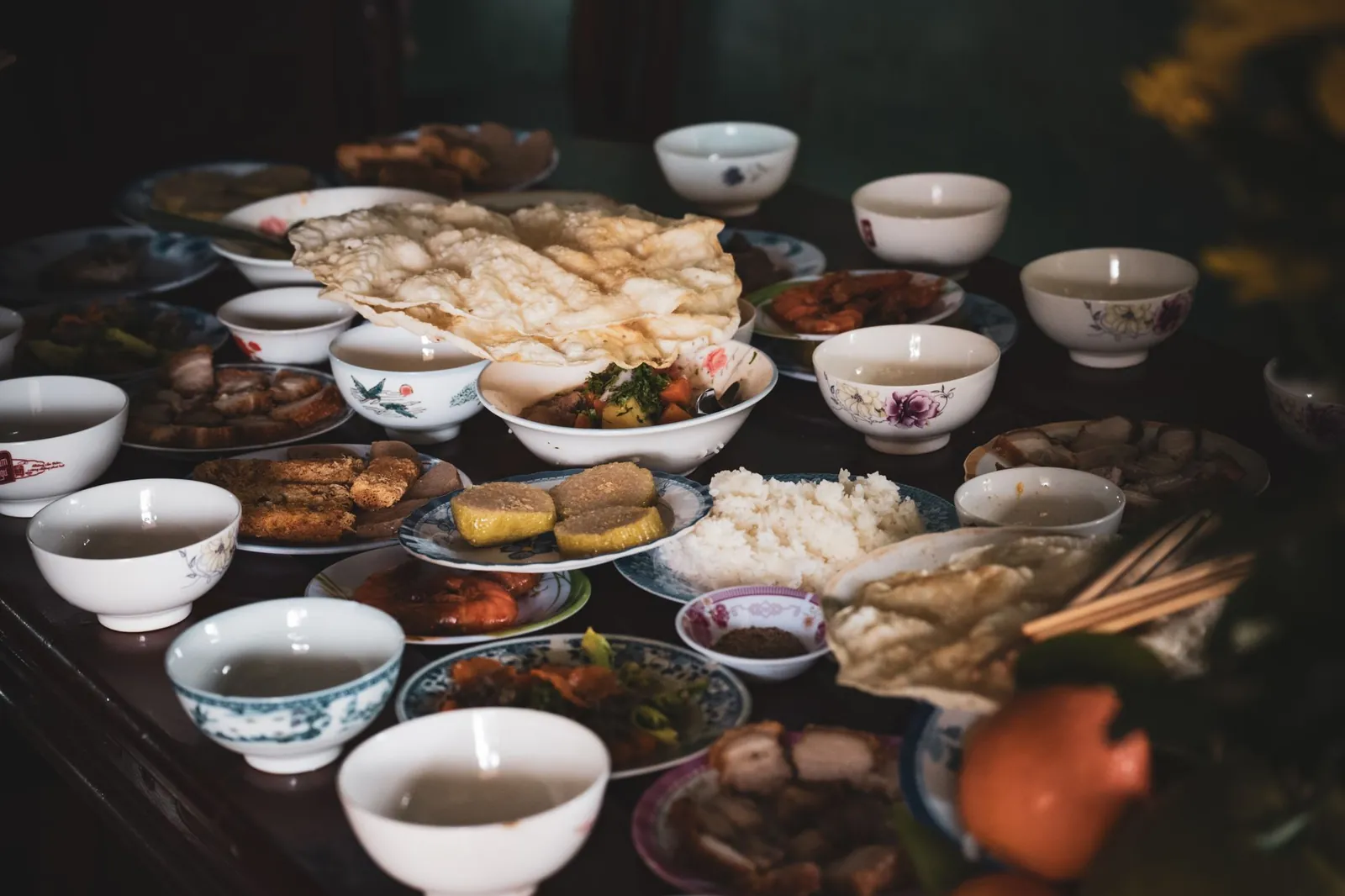 Mâm cỗ Tết bày kín bàn gỗ trong ánh sáng trầm
